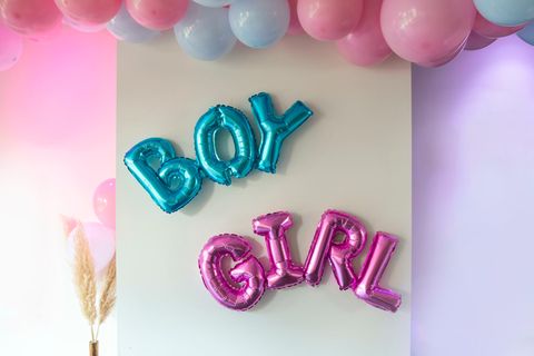 Luftballons mit dem Schriftzug Boy or Girl hängen auf einer Gender Reveal Party