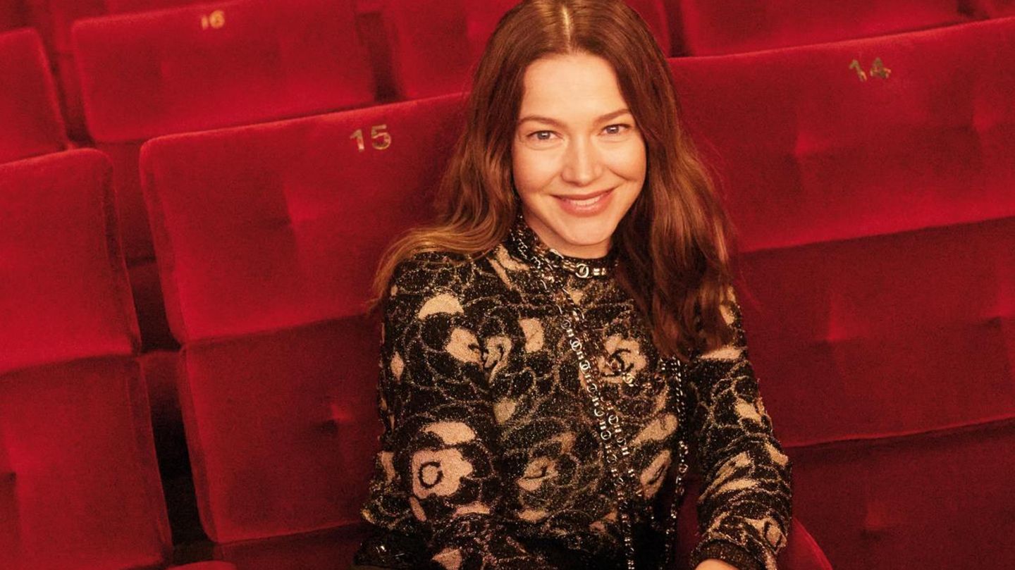 Schauspielerin Hannah Herzsprung sitzt in einem Kinosessel und lächelt in die Kamera