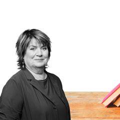 Frau Westermann vor einem Bücherstapel