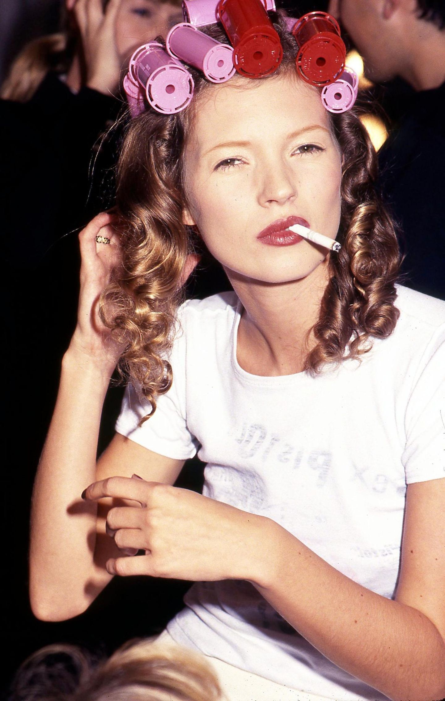 Kate Moss backstage bei einer Modenschau mit Lockenwicklern in den Haaren