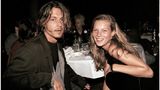 Kate Moss und Johnny Depp sitzen an einem Tisch und schauen in die Kamera