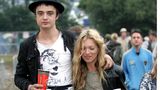 Kate Moss und Pete Doherty gehen eng beisammen über ein Schlammfeld bei einem Festival