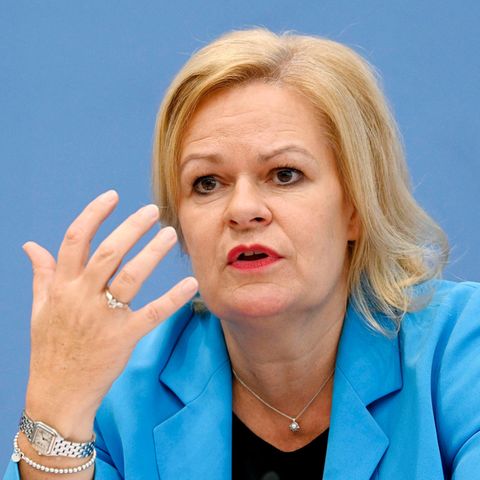 Innenministerin Nancy Faeser gestikuliert vor einer blauen Wand.