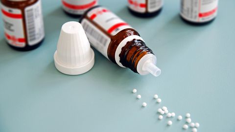 Homöopathie: Globuli liegen verstreut auf einem Tisch