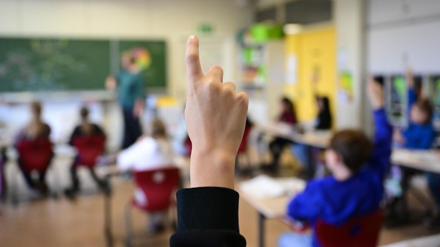 Kinder melden sich im Unterricht