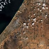 Die islamistische Hamas überfällt mit Raketenangriffen von Gaza aus Israel. Gleichzeitig dringen Terroristen der Hamas und anderer extremistischer Gruppen über Land, See und Luft nach Israel vor. Bei den überraschenden Angriffen töten sie rund 1200 Menschen und verschleppen etwa 240 in den Gazastreifen. Der abgetrennte Küstenstreifen links unten ist der Gazastreifen, die Rauchwolken zeigen die Raketeneinschläge im Süden Israels am Tag der Hamas-Attacke.