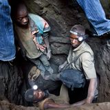 Im Kongo steigen Männer mit Taschenlampen an den Köfpen aus einem Minenschacht