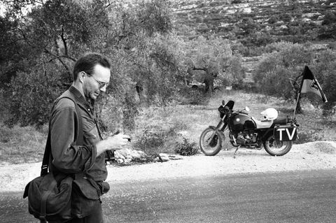 Fotograf Kai Wiedenhöfer im Westjordanland neben seinem Mottorrad, an dem die Fahne Baden-Württembergs flattert