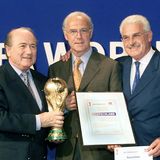 Auch nach seiner aktiven Fußballer-Karriere blieb Beckenbauer dem Deutschen Fußball Bund (DFB) treu. Zwischen 1984 und 1990 war er Teamchef der Deutschen Nationalmannschaft und ließ sich den Job dem Vernehmen nach mit eine Million Mark jährlich vergüten. Später war Beckenbauer maßgeblich dafür verantwortlich, dass die Weltmeisterschaft 2006 nach Deutschland ging. Dazu hat der DFB laut "Spiegel" mit Beckenbauer zwei Verträge geschlossen, einen im Oktober 2004 und einen im Oktober 2006. Diese haben Beckenbauer einen Betrag von insgesamt 5,5 Mio. Euro zugesichert. In diese Phase fällt allerdings auch die bitterste Phase Beckenbauers, die an seinem Image kratzt. Denn wie sich nachher herausstellte, soll die Vergabe wohl nicht mit rechten Dingen abgelaufen sein. Gerüchte um Schmiergelder und schwarze Koffer machten die Runde – und Franz Beckenbauer nicht gerade glücklich. Hier übergibt Fifa-Präsident Joseph S. Blatter (l.) im Juli 2000 den Zuschlag für die WM 2006 an Beckenbauer als DFB-Vizepräsidenten und DFB-Koordinator Fedor Radmann (r.).