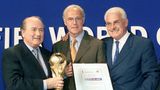 Auch nach seiner aktiven Fußballer-Karriere blieb Beckenbauer dem Deutschen Fußball Bund (DFB) treu. Zwischen 1984 und 1990 war er Teamchef der Deutschen Nationalmannschaft und ließ sich den Job dem Vernehmen nach mit eine Million Mark jährlich vergüten. Später war Beckenbauer maßgeblich dafür verantwortlich, dass die Weltmeisterschaft 2006 nach Deutschland ging. Dazu hat der DFB laut "Spiegel" mit Beckenbauer zwei Verträge geschlossen, einen im Oktober 2004 und einen im Oktober 2006. Diese haben Beckenbauer einen Betrag von insgesamt 5,5 Mio. Euro zugesichert. In diese Phase fällt allerdings auch die bitterste Phase Beckenbauers, die an seinem Image kratzt. Denn wie sich nachher herausstellte, soll die Vergabe wohl nicht mit rechten Dingen abgelaufen sein. Gerüchte um Schmiergelder und schwarze Koffer machten die Runde – und Franz Beckenbauer nicht gerade glücklich. Hier übergibt Fifa-Präsident Joseph S. Blatter (l.) im Juli 2000 den Zuschlag für die WM 2006 an Beckenbauer als DFB-Vizepräsidenten und DFB-Koordinator Fedor Radmann (r.).