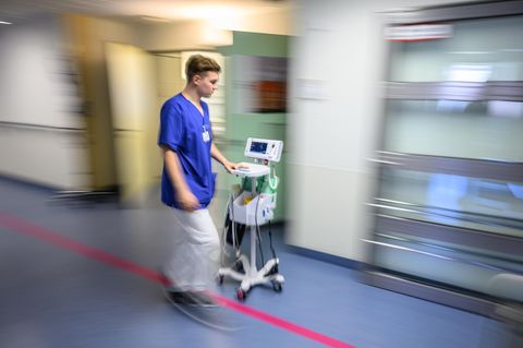 Ein Pfleger geht über den Flur eines Krankenhauses