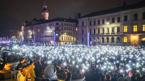 Teilnehmer leuchten mit den Taschenlampen ihrer Handys während einer Demonstration vor dem Bundesverwaltungsgericht in Leipzig