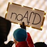 Ein Demonstrant hält ein Schild mit "no AfD" in die Höhe