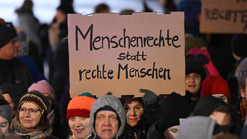 Eine Demonstrantin trägt ein Schild "Menschenrechte statt rechte Menschen"