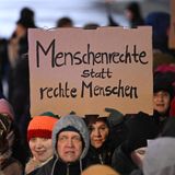 Eine Demonstrantin trägt ein Schild "Menschenrechte statt rechte Menschen"