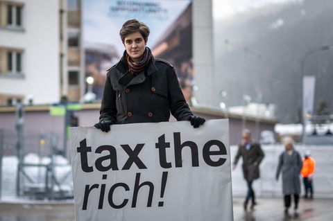 Marlene Engelhorn mit einem Schild "tax the rich"
