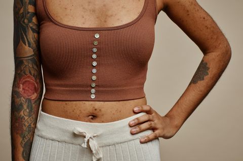 Frau mit bauchfreiem Shirt – der Bauchnabel ist zu sehen