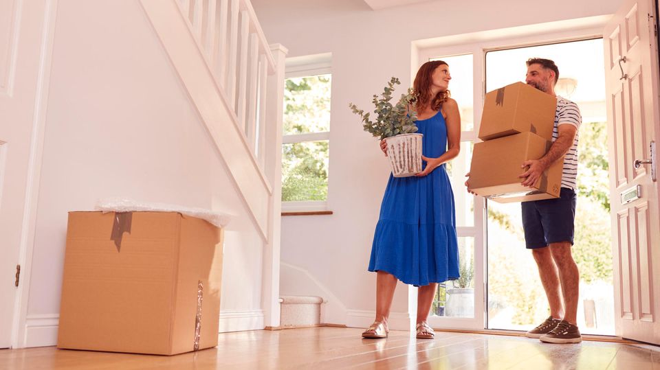Eine Frau und ein Mann ziehen in ein Haus ein