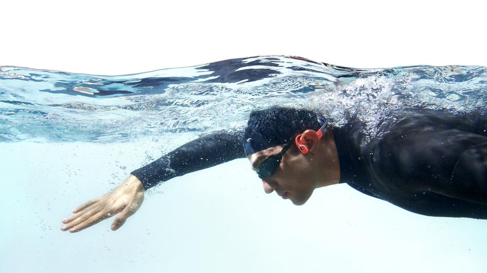 Wasserdichte Kopfhörer: Schwimmer in Neoprenanzug mit Kopfhörern