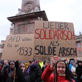 Eine Demonstrantin hält in Potsdam ein Schilt mit der Aufschrift "lieber solidarisch als solide arisch"