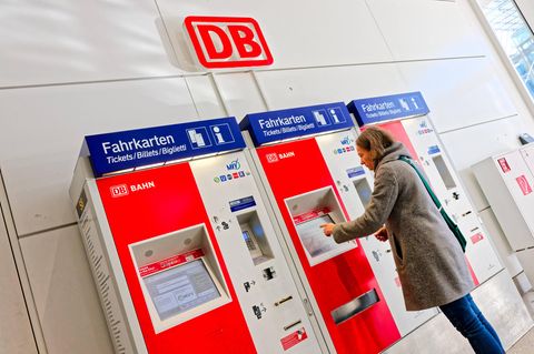 Eine Frau steht an einem Ticketautomaten der Deutschen Bahn