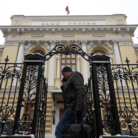 Die russische Zentralbank in Moskau. Ein Mann geht durch ein altes Tor