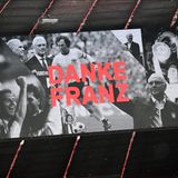 Als die Trauergäste in die Allianz Arena kommen, sehen sie eine Anzeigetafel, auf der Fotos des Verstorbenen und der Schriftzug "Danke Franz" zu sehen sind.