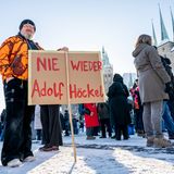 Ein Demonstrant steht am Samstag mit einem Banner mit der Aufschrift "Nie wieder Adolf Höckel" auf dem Domplatz in Erfurt
