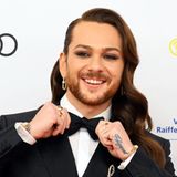 Moderator Riccardo Simonetti fliegt über den roten Teppich ein und richtet noch einmal seine Fliege