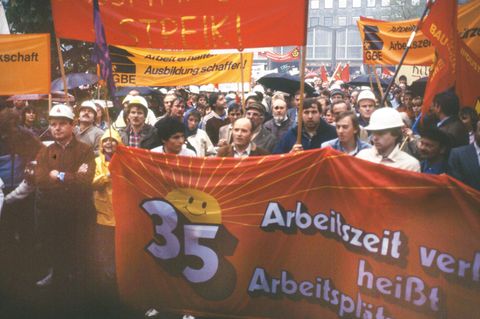 In den 1980er-Jahren steht die 35-Stunden-Woche im Mittelpunkt vieler Arbeitskämpfe. 1984 kommt es zu Streiks in der Metall- und Druckindustrie. Sie zählen zu den härtesten in der westdeutschen Geschichte. "Mehr Zeit zum Leben, Lieben, Lachen", skandiert etwa die IG Metall. In Hessen und Baden-Württemberg streiken die Beschäftigten der Metallindustrie sieben Wochen lang für die 35-Stunden-Woche, während die Drucker sogar bundesweit zwölf Wochen im Ausstand ist. Die Arbeitgeber reagieren mit massiven Aussperrungen. Letztendlich wird in beiden Branchen die 38,5-Stunden-Woche vereinbart. Später wird die Arbeitszeit auch in anderen Branchen verkürzt. 52 Tage dauert der Ausstand insgesamt und führt zum Verlust von zehn Millionen Arbeitstagen. Die Gewerkschafts-Streikkassen sind dadurch stark belastet. Die Kosten für die Streiks von 1984 werden von den Gewerkschaften auf 320 Millionen D-Mark geschätzt.