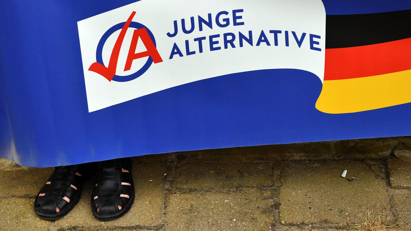 In Apolda, Thüringen, hält ein Mann in schwarzen Sandalen hält ein Plakat der AfD-Jugendorganisation Junge Alternative