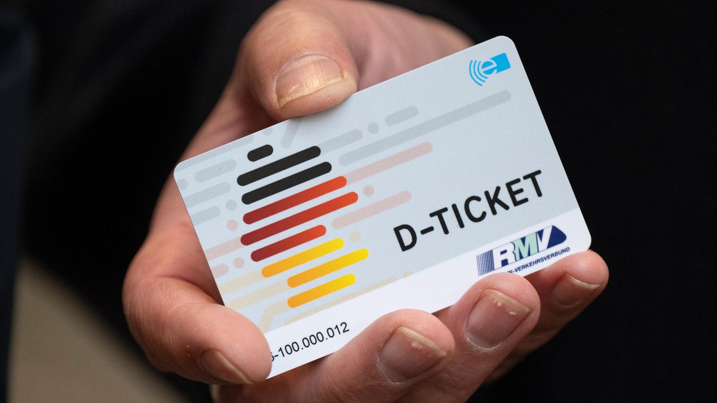 Ein Deutschlandticket in der rechten Hand eines Mannes