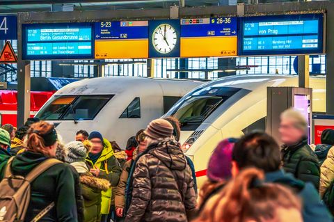 Eine Menschentraube steht vor wartenden Zügen im Hauptbahnhof München