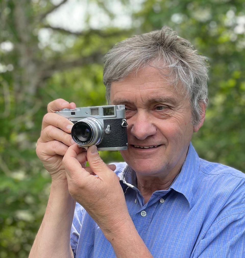 Portrait des Fotografen Michael Wohl-Iffland der Schnittblumen- und Früchte vertikal aufgeschnittennund fotografiert hat. Michael Wohl-Iffland beim Fotografieren von Blumen
