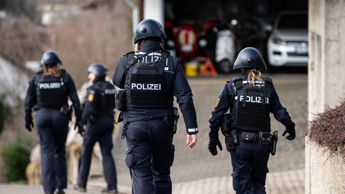 Polizeibeamte gehen mit voller Ausrüstung durch ein Wohngebiet in Unterkirnach. Weil eine Zwangsräumung zu eskalieren drohte, ist die Polizei derzeit mit einem Großaufgebot im Einsatz. 