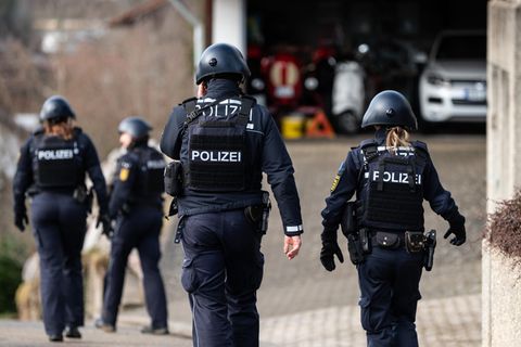 Polizeibeamte gehen mit voller Ausrüstung durch ein Wohngebiet in Unterkirnach. Weil eine Zwangsräumung zu eskalieren drohte, ist die Polizei derzeit mit einem Großaufgebot im Einsatz. 