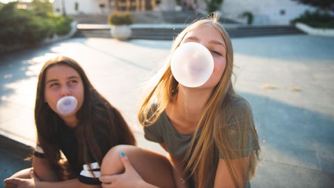 Zwei Mädchen machen Kaugummiblasen