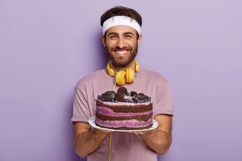 Ein Sportler hält eine Torte in der Hand und lächelt (Bebilderung Doping mit Backpulver)