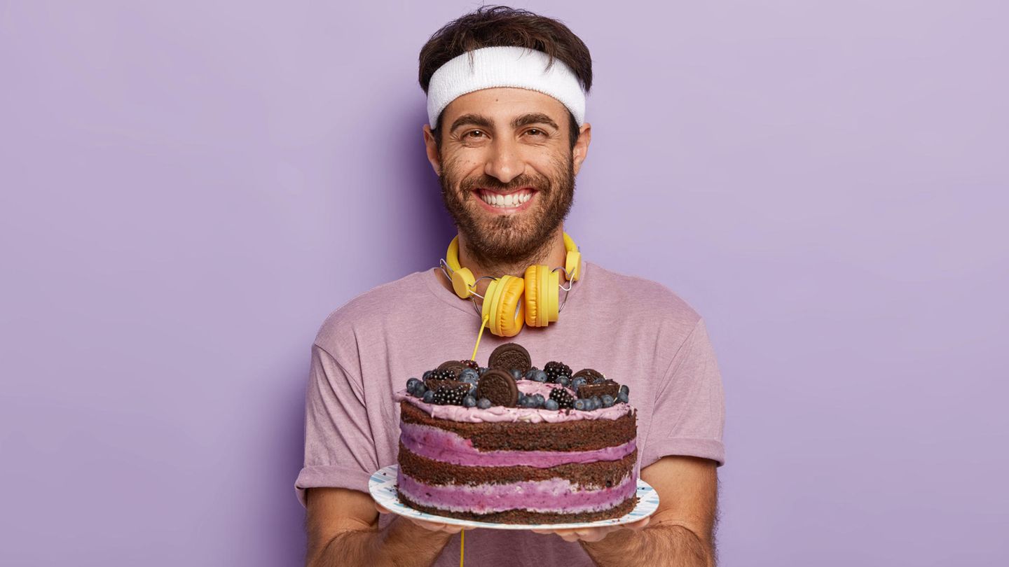 Ein Sportler hält eine Torte in der Hand und lächelt (Bebilderung Doping mit Backpulver)