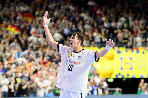 Julian Köster jubelt auf dem Handballfeld, im Hintergrund deutsche Fans
