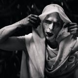 Christian Bale mit weißem Make-up und Tuch über dem Kopf