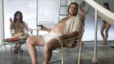 Christian Bale sitzt nur mit Shorts und offenem Hemd bekleidet auf einem Gartenstuhl