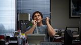 Christian Bale sitzt in einem Büro und telefoniert