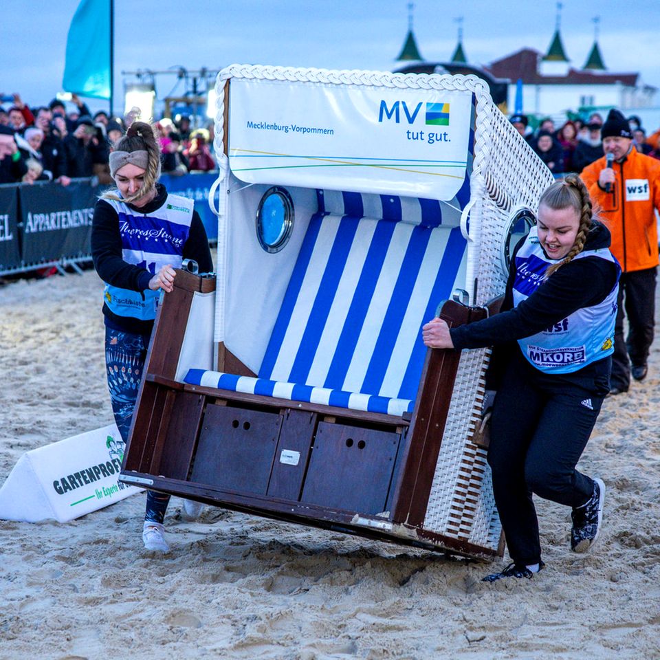 Ahlbeck, Deutschland. Ein Frauen-Team läuft in einem der Finalläufe bei der 16. Strandkorb WM in Mecklenburg-Vorpommern. Zweierteams müssen bei dem Wettkampf einen etwa 60 Kilogramm schweren Strandkorb über eine 20 Meter lange Strecke durch Ostseesand ins Ziel schleppen. Der Rekord steht seit Jahren bei 4,91 Sekunden.