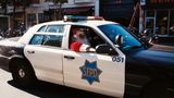 Ein als Weihnachtsmann verkleideter Polizist in einem Polzeiauto