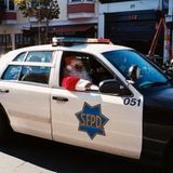 Ein als Weihnachtsmann verkleideter Polizist in einem Polzeiauto