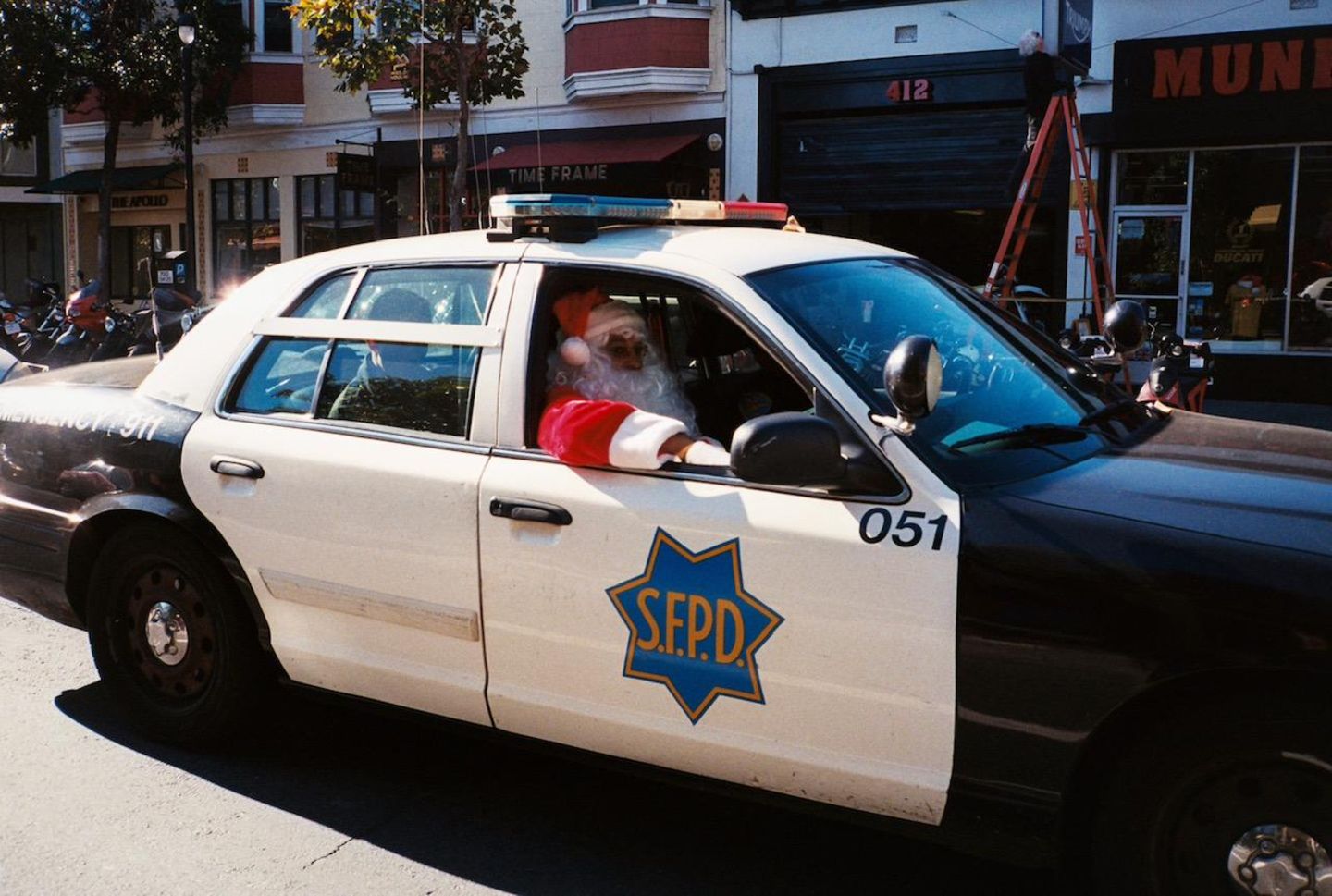 Ein als Weihnachtsmann verkleideter Polizist in einem Polzeiauto