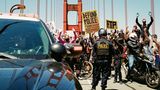Polizisten stehen auf der Golden Gate Bridge einer Demonstrationszug gegenüber