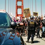 Polizisten stehen auf der Golden Gate Bridge einer Demonstrationszug gegenüber