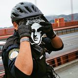 Ein Polizist der Golden Gate Bridge Patrol hält sich den Ausdruck des Gesichts der Venus von Milo vors Gesicht